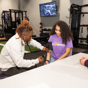 Two students practicing taking blood pressure